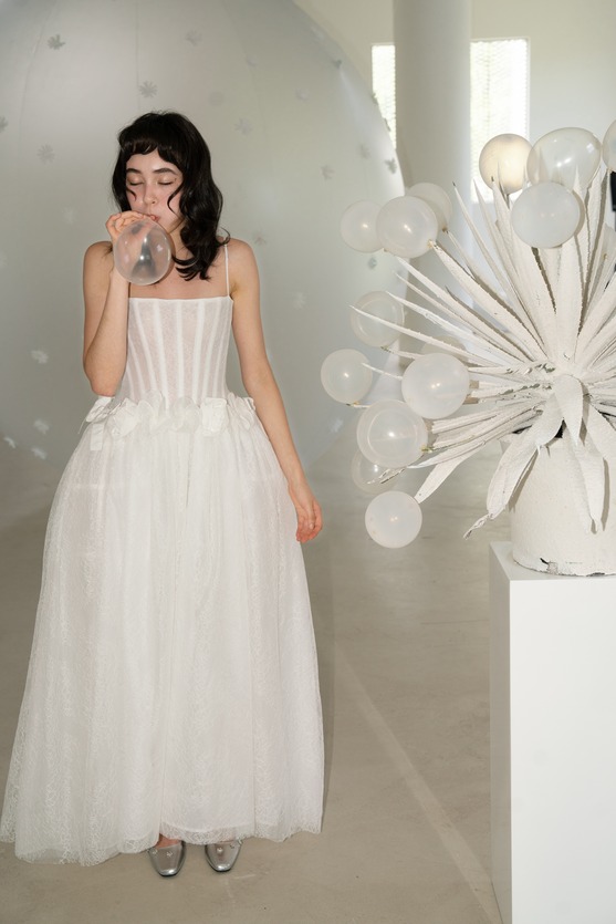A bride in a white Futur gown beside a sculptural floral installation